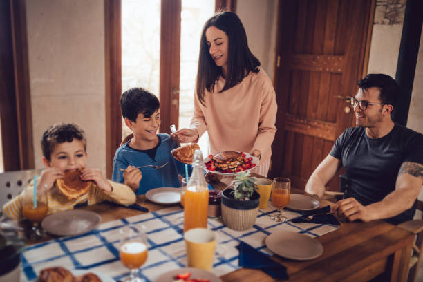 istock Young mother serving happy son pancakes for breakfast 983406218