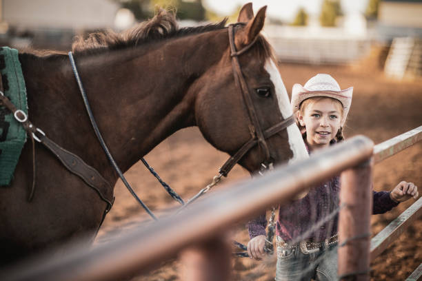 istock Young cowgirl with her horse. 983409414