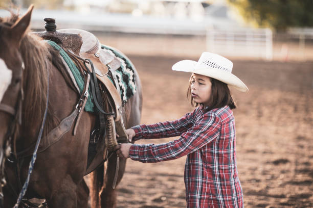 istock Young cowgirl with her horse. 983409462