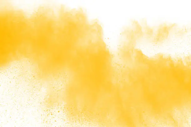 Photo of abstract yellow dust explosion on  white background. abstract yellow powder splatter on white background. Freeze motion of yellow powder splash.