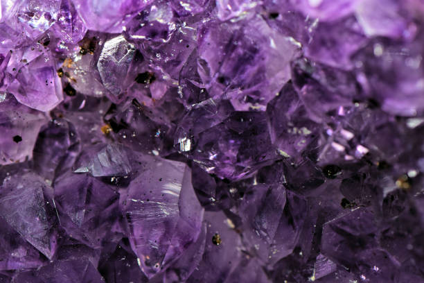 A full frame abstract background close up image of a purple Amethyst crystal agate which is commonly used in natural and alternative medicine for healing and relaxation.