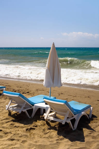 istock Sun beds stand against the sea with waves. 983422908