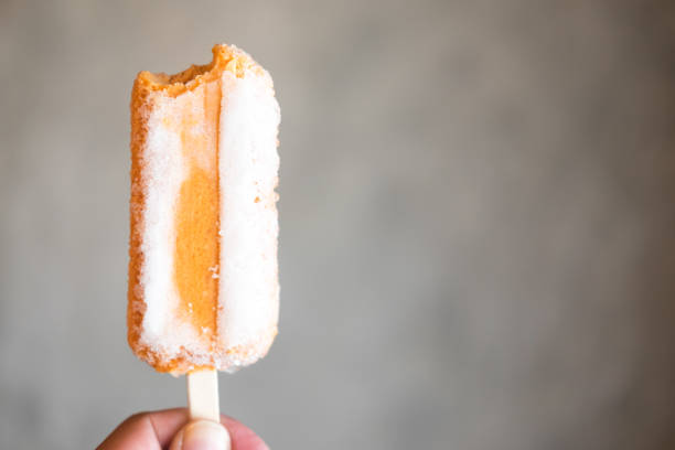 istock Young hand holding Thai milk tea ice cream bar 983425680