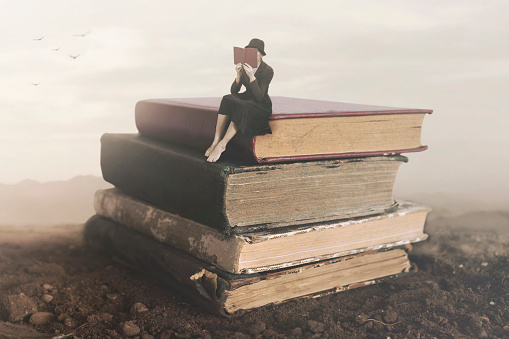 Imagen surrealista de una sesión de lectura de mujer encima de un libro photo