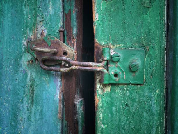istock Old rusty latch at a wooden door, vintage latch background 983433588