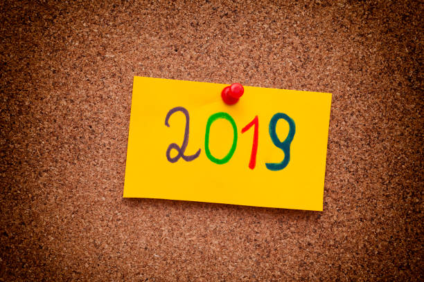 istock 2019 year written on yellow paper note on cork board 983450782