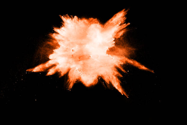 istock abstract orange dust explosion on  black background. abstract orange powder splattered on black background, Freeze motion of orange powder splash. 983457764