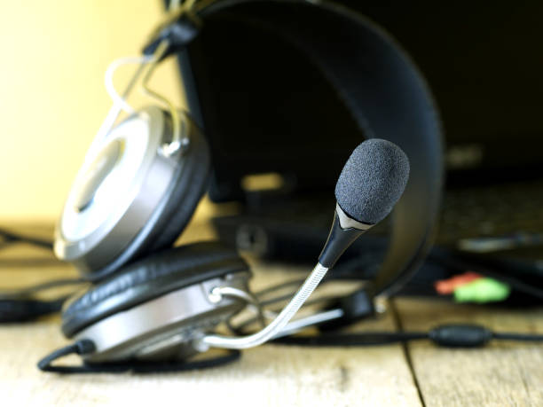 istock headset with microphone connected to laptop, shallow dof, focus on microphone, blurred background 983462468