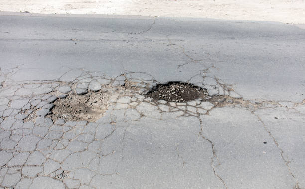 istock bad asphalt road, pit on the road 983466804