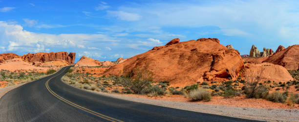 пустынная дорога и красные скалы - asphalt highway desert valley стоковые фото и изображения