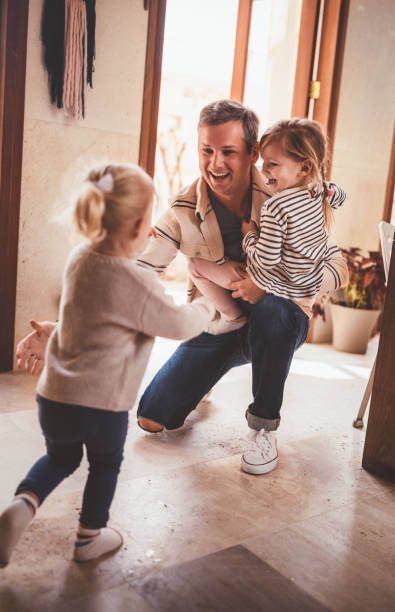 istock Little girls running towards father when coming home from work 983479350