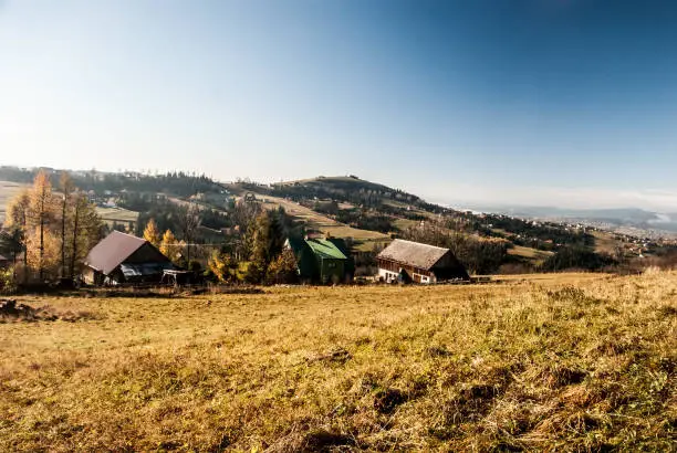 nice autumn Silesian Beskids near Koniakow village with dispersed settlement, meadow, Ochodzita hill and clear sky in Poland