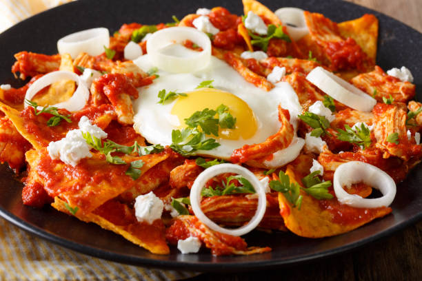 istock Mexican breakfast: chilaquiles with egg and chicken close-up. horizontal 983512464