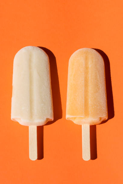 istock Lemon and banan popsicles on an orange background. Close-up 983517350