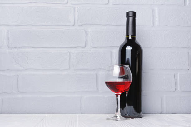 istock Red wine bottle and glass for tasting with copy space 983576616