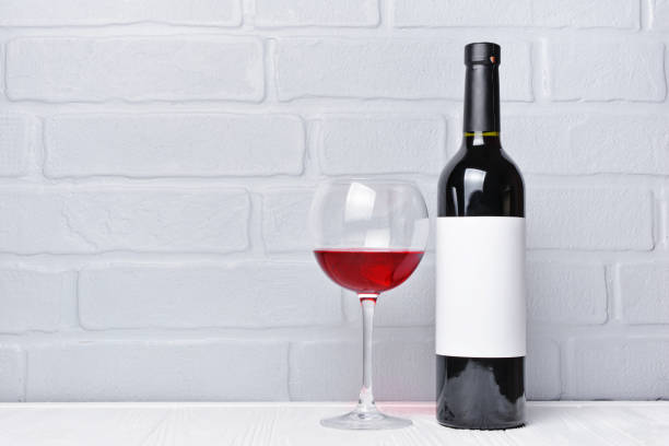 istock Red wine bottle with empty label and glass 983576722
