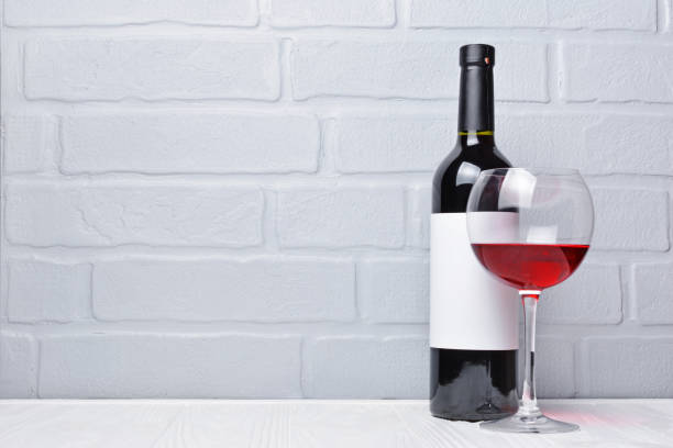 istock Red wine bottle with empty label and glass 983576736