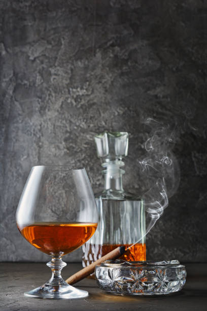 istock Strong alcoholic drink cognac in sniffer glass and decanter with smoking cigar 983577268