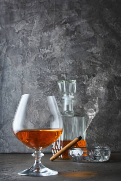 istock Strong alcoholic drink cognac in sniffer glass and decanter with smoking cigar 983577270