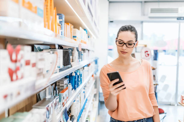 istock Woman uses smart phone while in pharmacy 983596306