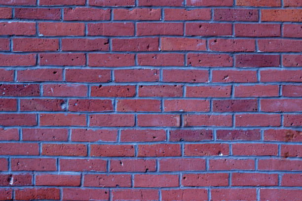 istock Shabby chic old weathered rosy red colored brick wall background 983596624