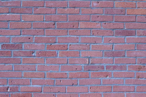 istock Shabby chic old weathered rosy red colored brick wall background 983601278