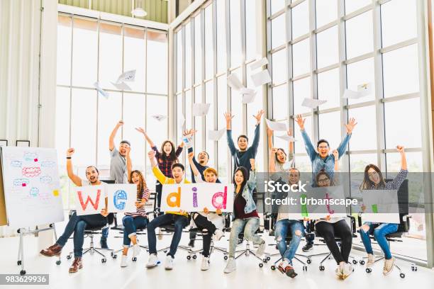 Multiethnic Diverse Group Of Happy Business People Cheering Together Celebrate Project Success With Papers Written We Did It Coworker Teamwork Team Achievement Or Small Business Startup Concept Stock Photo - Download Image Now