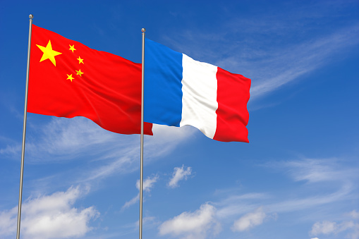 China and France flags over blue sky background. 3D illustration