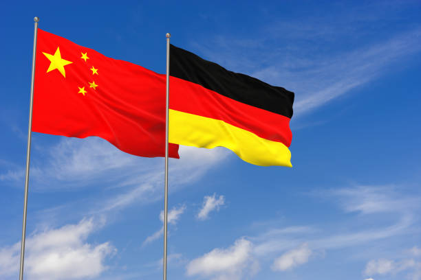 China and Germany flags over blue sky background. 3D illustration stock photo