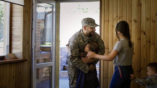 istock Soldier entering home with happy family 983636614