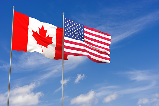 USA and Canada flags over blue sky background. 3D illustration