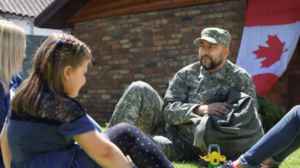 istock Soldier with family on green backyard 983636970