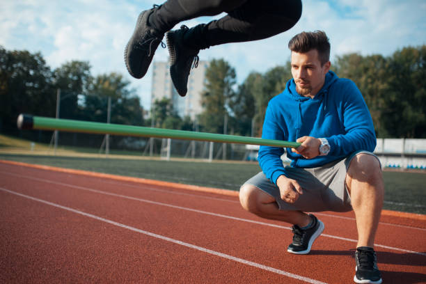 istock morning exercises with personal coach with bar jumping; 983656218