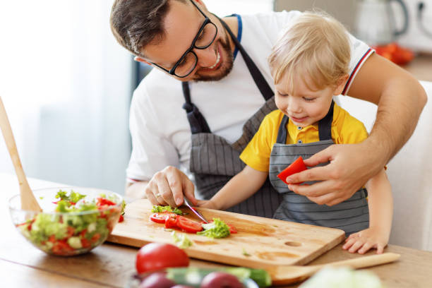 istock happy family father with son preparing vegetable salad 983668788