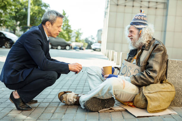 istock Helpful office worker asking street person about needed food 983682956