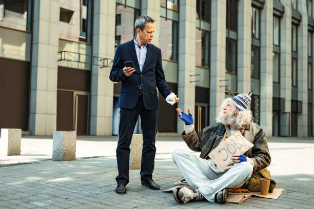 istock White collar worker giving his burger to elderly homeless man 983692642