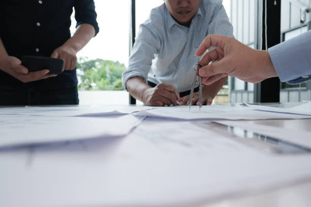 istock architect working on real estate project with partner at workplace. engineer discussing on living house blueprint at office. construction & building concept 983710384