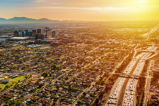 An aerial view of downtown Phoenix, Arizona and the surrounding urban area from an altitude of about 2000 feet over the desert floor during the hours of dusk.