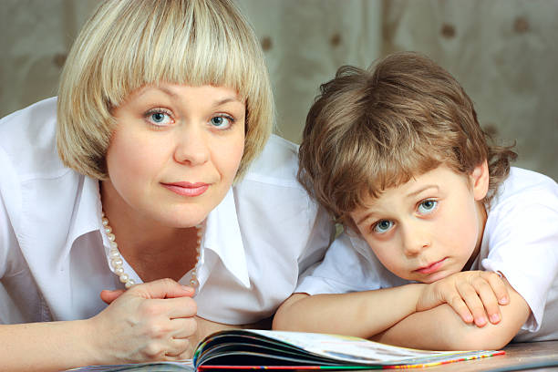 istock woman and little boy reading book 98374511