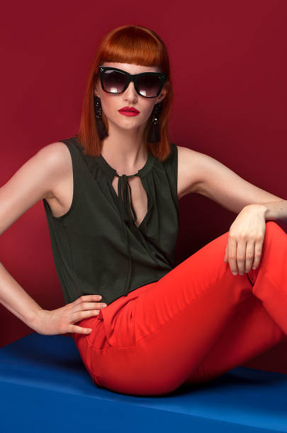 istock Fashionable redhead woman posing in studio. 983753090