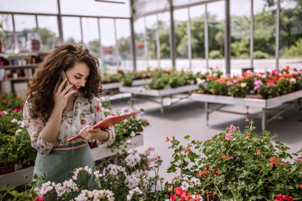 piuttosto giovane fioraio organizzare la consegna - florist telephone flower business foto e immagini stock