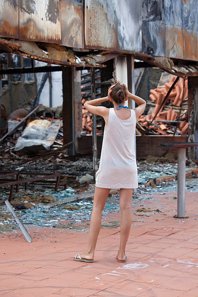 istock shocked woman and burned out house 98378591