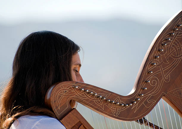 istock Young woman playing a harp 98379960