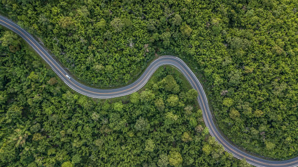 vista aérea da estrada da floresta no sudeste da ásia, vista aérea de uma estrada provincial, passando por uma floresta, tailândia. - asphalt high angle view street traffic - fotografias e filmes do acervo