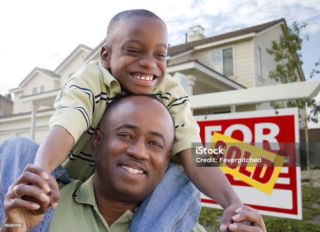 Padre con il figlio davanti al segno venduto e la casa - Foto stock royalty-free di Davanti