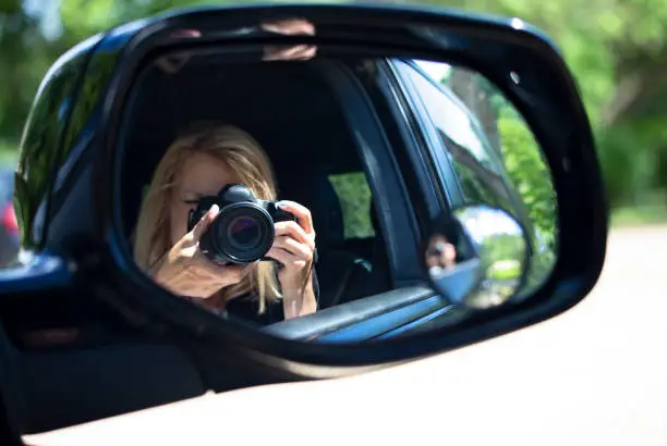 Photo of Tourist Photographer Reflected in Side Mirror