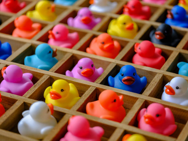 istock Many multi-colored rubber ducks in wood pigeon hole compartments. 983876814