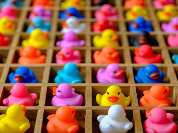 istock Many multi-colored rubber ducks in wood pigeon hole compartments. 983876816