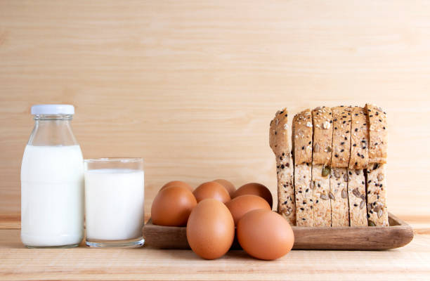 leite, ovos e pão na mesa de madeira. com espaço de cópia para o texto. - bakery bread carbohydrate cereal plant - fotografias e filmes do acervo