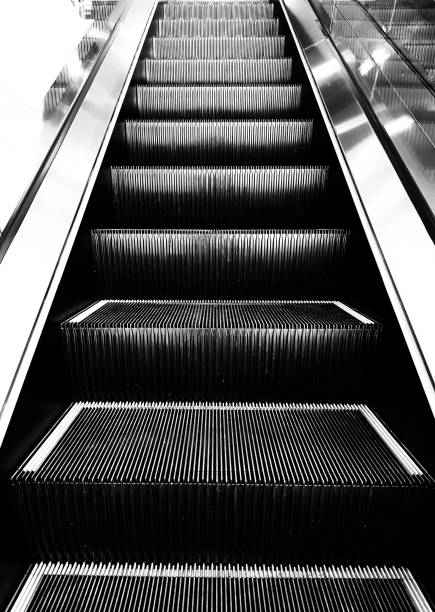 istock Close up escalator black and white technology use for up and down indoor in shopping mall, building, graphic, background or texture. 983901818
